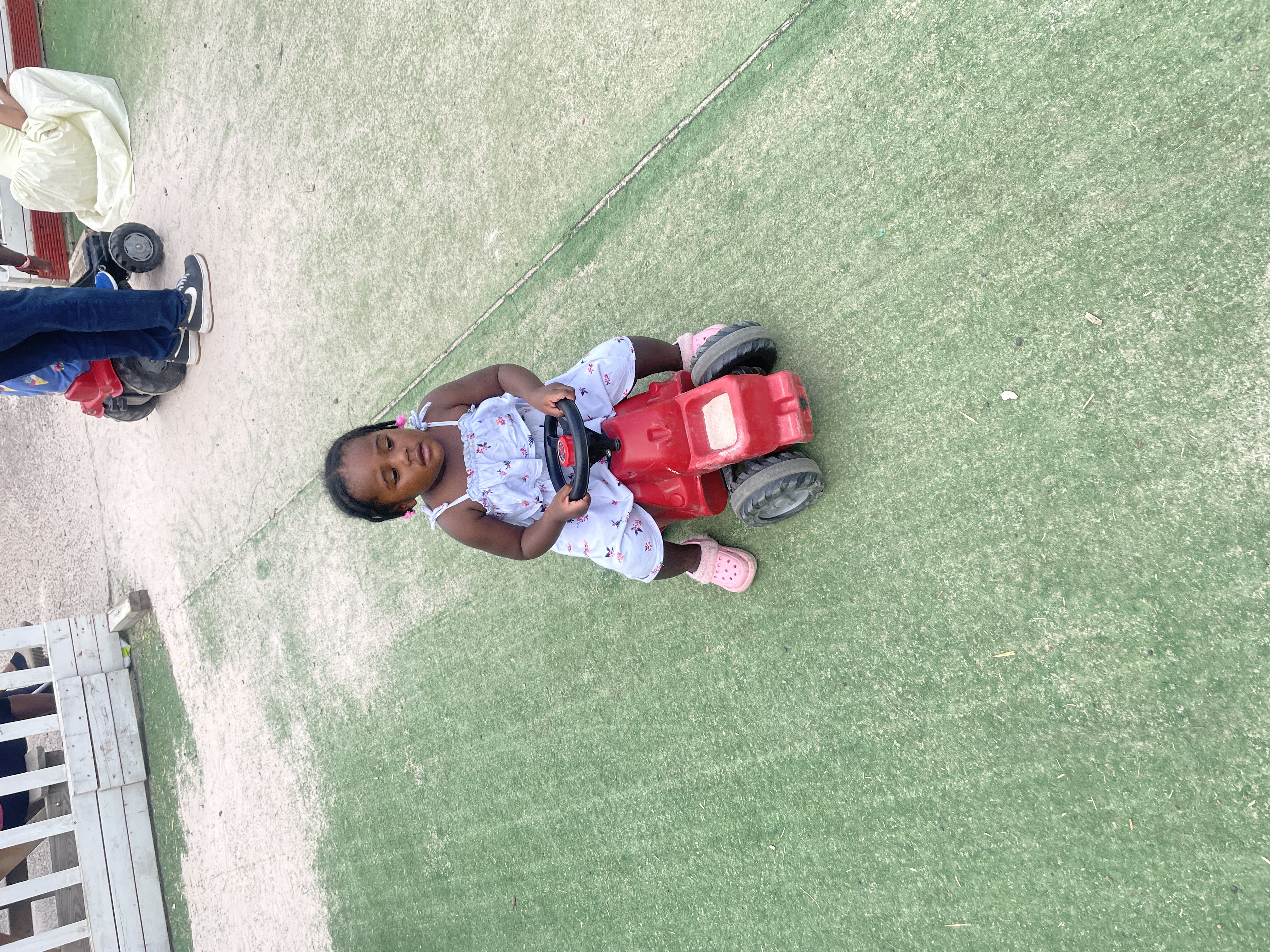 A child enjoying an outdoor ride-on toy